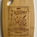 Lustiges Frühstücksbrettchen aus Bambus mit dem gravierten Spruch: „Achtung Küchenverbrechen“ als originelle Geschenkidee.