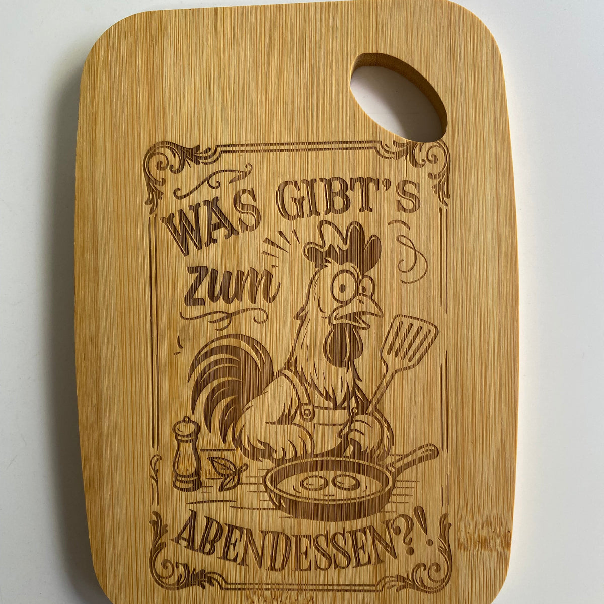 Robustes Holzbrettchen für das Abendbrot mit der gravierten Frage: „Was gibt's zum Abendessen“ als Küchen-Deko.